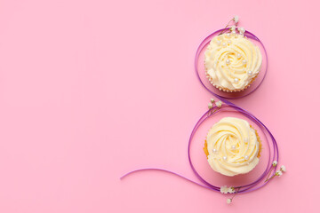 Obraz premium Figure 8 made of violet ribbon and cupcakes on color background. International Women's Day celebration