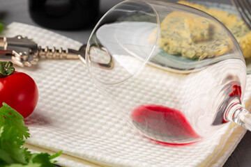 Glass of wine and piece of cheese on table close up