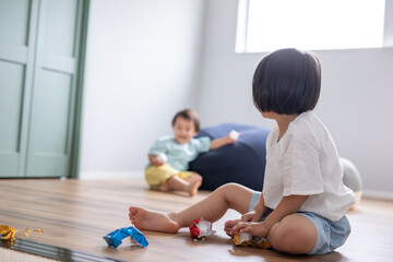 Fototapeta premium 綺麗な新築の家に女の子と男の子が兄弟で遊んでいる姿 kids home