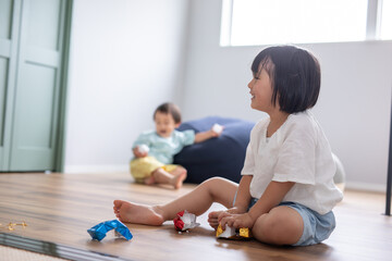 綺麗な新築の家に女の子と男の子が兄弟で遊んでいる姿　kids home