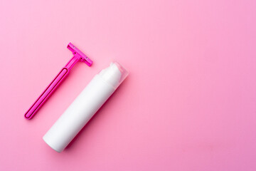 Shaving gel and disposable shaver on pink background top view