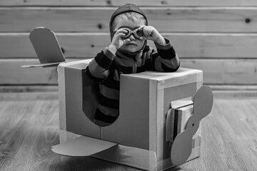 Kid, pilot school, innovation. Kids Travel, imagination. Little boy child play in cardboard plane,...