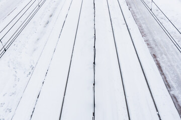 Railway top view background. Train track texture. White transportation background. Winter landscape. Snow on the railway. Icy train plaftorm. Train station covered in snow.