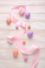 Beautiful Easter eggs on light wooden background