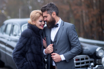 Couple at a retro or vintage car outdoor. Retro style. Couple in love and relations. Vintage dress.