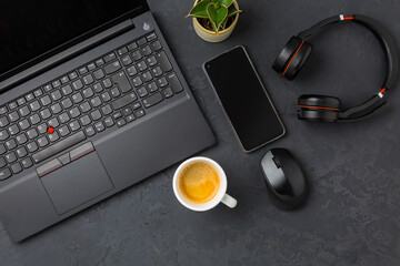 Working place and office desk with coffee, laptop, headset and smarthpone