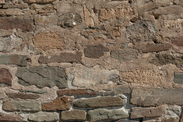Stony wall of medieval castle close up, authentic stonework for texture or background, masonry cobblestones and stones