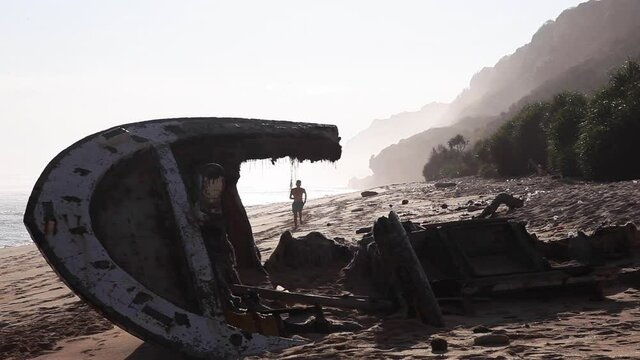 Caucasian white running to abandoned boat in Bali