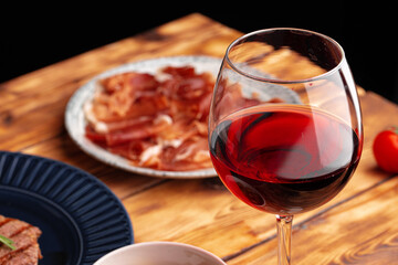 Meat slicing and wine on gray background