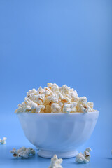 Popcorn in bowl on a blue background. Close up. Top view