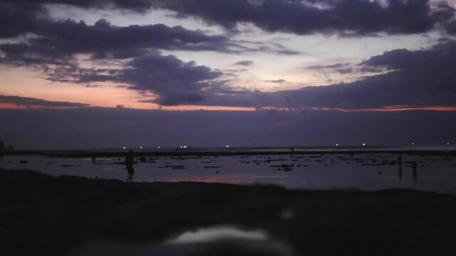 Balinese people fishing at dusk in the beach
