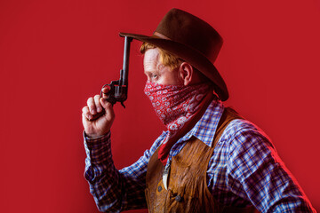 Portrait of man wearing cowboy hat, gun. Portrait of a cowboy. West, guns. Portrait of a cowboy. American bandit in mask, western man with hat. Portrait of cowboy in hat