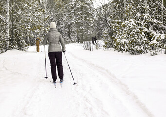 A woman is skiing in a snowy forest. Healthy lifestyle. Winter sport. Copy space.