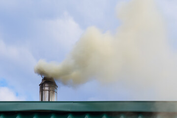 Smoke comes from the chimney. Stove heating. Pollution of the atmosphere by soot.