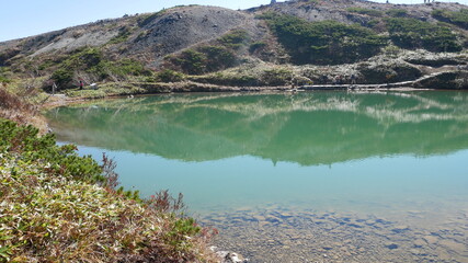 pond with transparency and emerald green at Hakuba, Japan, early autumn 