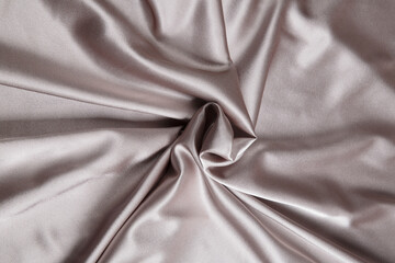 Colored silver textile satin fabric folded in folds and waves with highlights and texture
