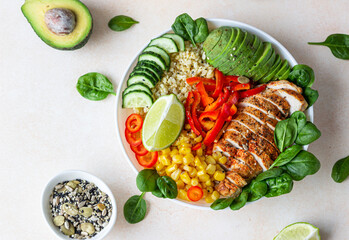 Bowl with bulgur, grilled chicken, bell pepper, cucumber, corn, avocado and spinach. Buddha bowl. Healthy food concept. Top view.
