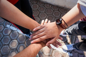 Group of friends on the park stacking hands