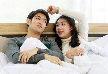 Man and woman lovers laying on bed and sharing sweet time together in winter season