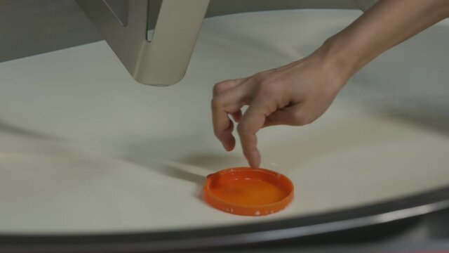 an orange lid floats on the surface of milk in a large tank. A way to find out the flocculation point in cheese making.