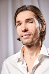 Fototapeta premium Portrait of handsome young man in a white shirt in studio against white background
