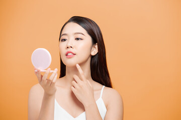 beautiful woman smartens up in front of compact mirror