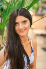 Portrait of a beautiful young smiling caucasian woman looking at camera outdoors