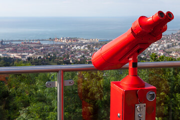 red binoculars for watching over the city from the top of the hill 