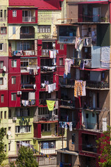 colorful laundry is dried on the balconies of a multi-storey building