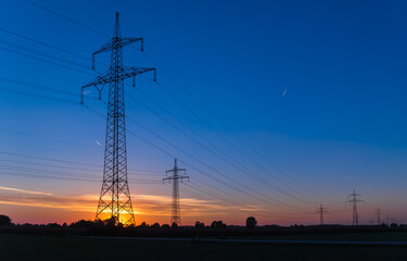 Fototapeta premium Beautiful sunset with overland high voltage lines near Tabertshausen, Bavaria, Germany
