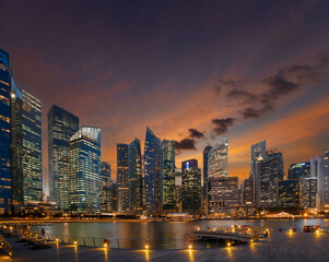 Singapore central business district view from illuminated waterfront promenade at sunset.