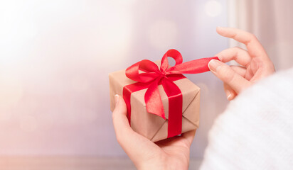 woman holding a gift box in her hand and untie a bow