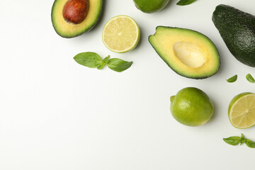 Avocado, lime and basil on white background, space for text