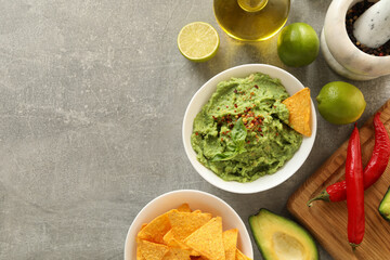 Concept of tasty eating with guacamole and ingredients on gray background
