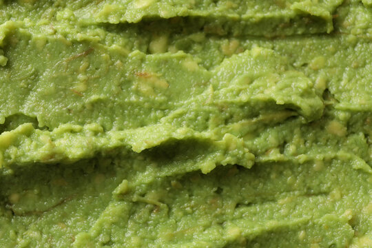 Fresh guacamole texture on whole background, close up