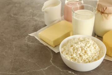 Different fresh dairy products on gray table, space for text