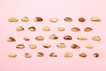 Flat lay with tasty brazil nuts on pink background
