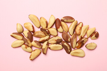 Tasty brazil nuts on pink background, top view