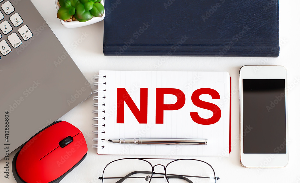Poster nps text written on a notebook with pencils