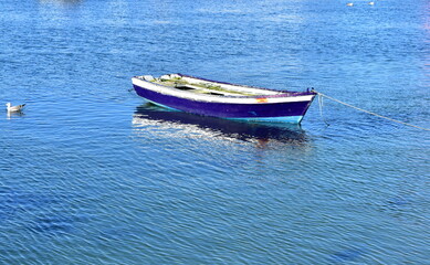 Fototapeta premium Old blue wooden small boat floating on the sea at famous Rias Baixas in Galicia Region. Spain. 