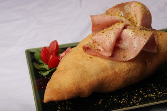 Close up of fried panzerotto hot stuffing. Traditional food of Italy