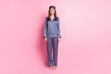 Full length photo portrait of adorable woman standing next to blank space isolated on pastel pink colored background