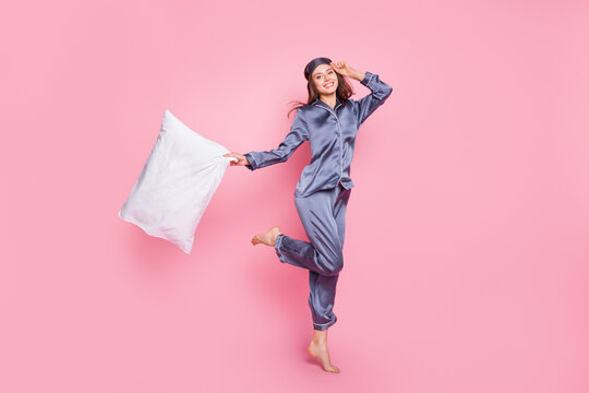 Full length body size photo of girl in sleepwear keeping pillow awakening in the morning isolated on pastel pink color background