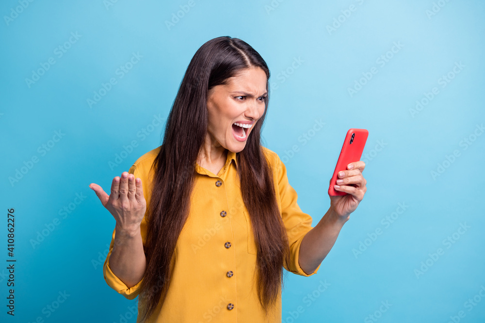 Sticker Portrait of displeased lady staring phone open mouth yell loud bad fake news isolated on blue color background