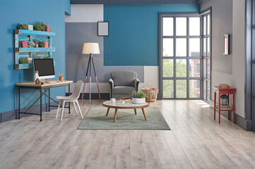 Decorative blue and grey wall background, home decoration interior style with sofa carpet middle table frame and working desk style.
