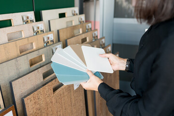 Young woman choosing materials for home renovation. Interior designer  matching samples the color...