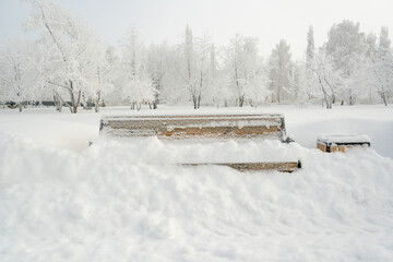 A bench covered with snow in a winter park