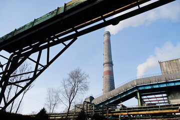 Almaty, Kazakhstan - 02.04.2021 : Metal structure on the background of a smoking pipe of a heating plant