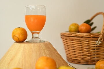 orange juice with fruits in the wooden bowl white background