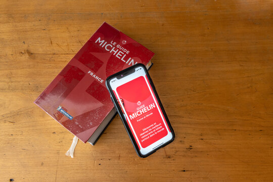 Paris, France - January 15, 2020 - Red Michelin guide book and smartphone application, which reviews restaurants.